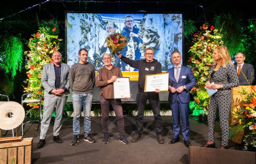 Het team van Oesterzwammerij ontvangt de Themaprijs Circulair Ondernemen uit handen van burgemeester Gido Oude Kotte van Aalsmeer(rechts) en voormalig astronaut André Kuipers.